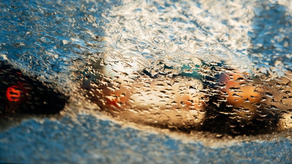 Melting frozen windshield on a cold winter day