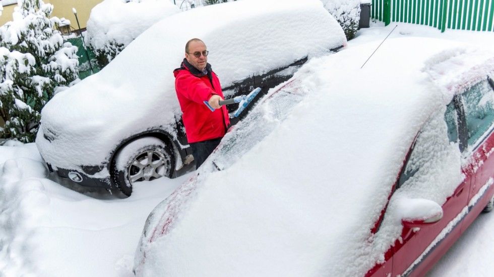 snow is shoveled away from a car. snow removal in winter